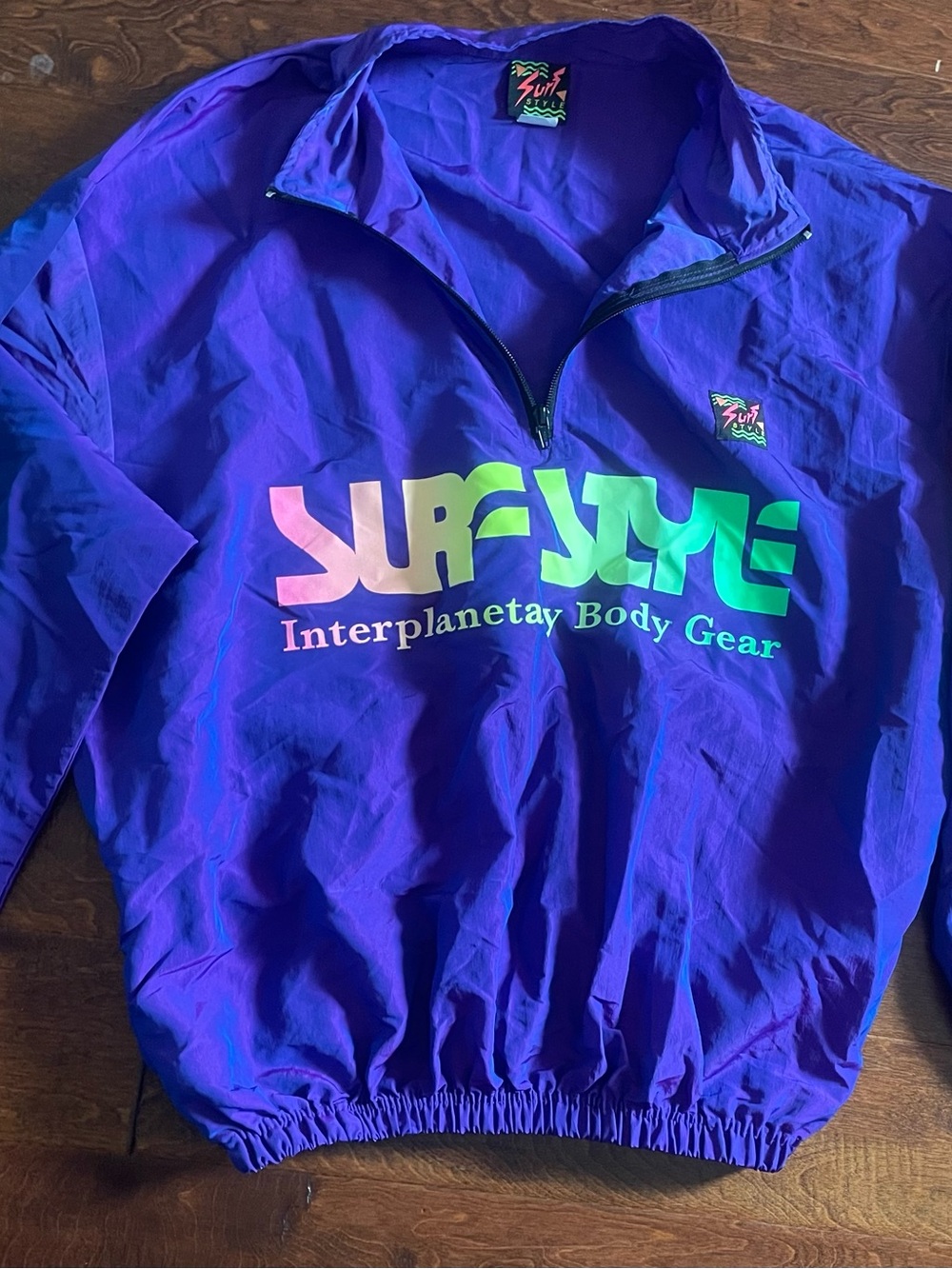 surf style purple pullover with neon gradient logo